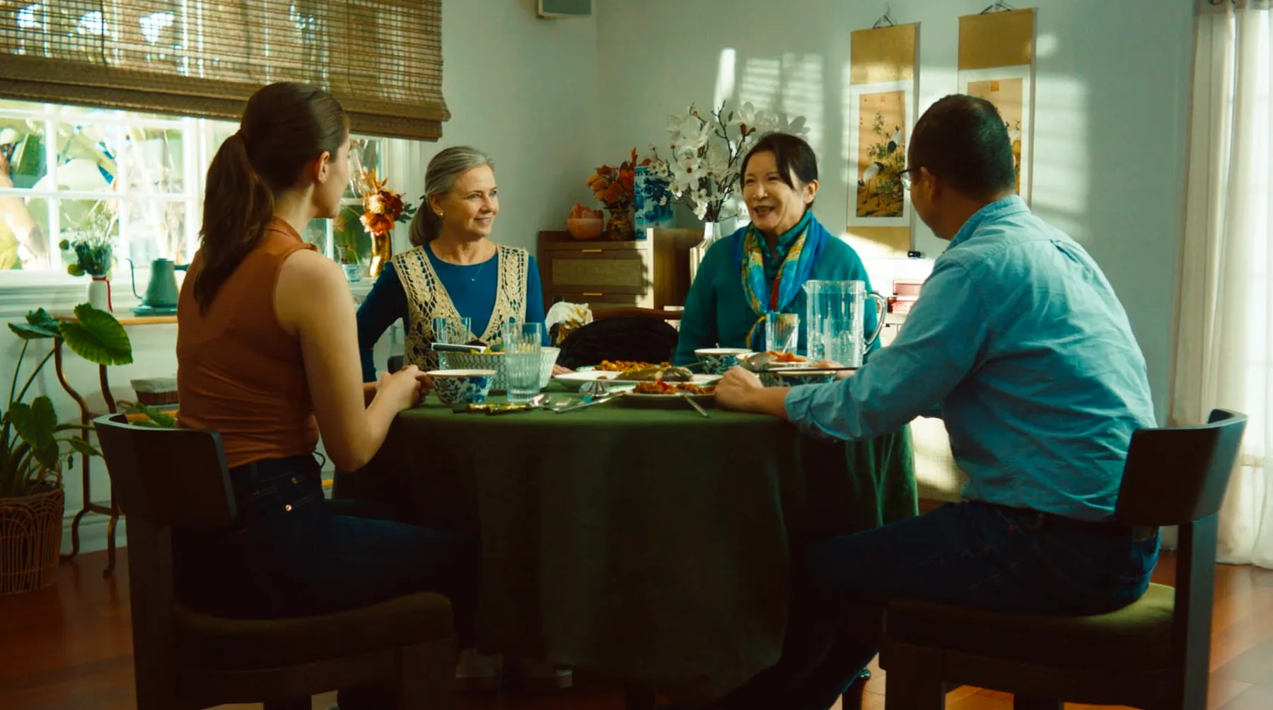 Two families seated around a dining table in Family Plan